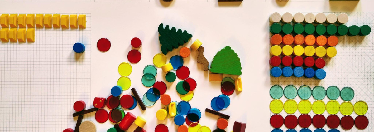 Spielsteine liegen ungeordnet auf einem Haufen. Drumherum liegen sie ordentlich sortiert.